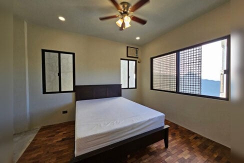 Second bedroom with parquet floors and a ceiling fan