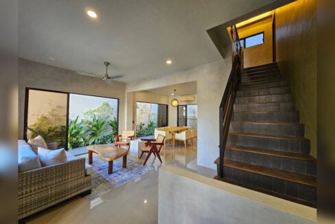 Living room with sliding glass doors to a garden courtyard, beside the staircase