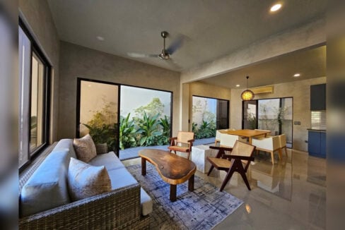 Living and dining area opening onto planted courtyards