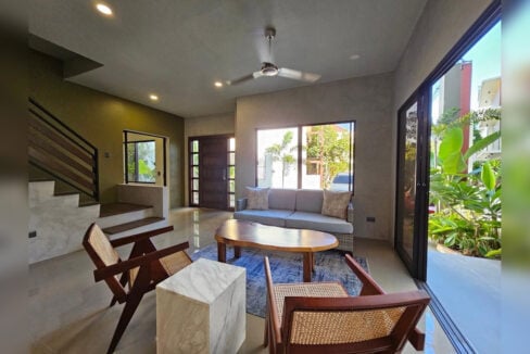 Living room with rattan chairs, looking toward the front door