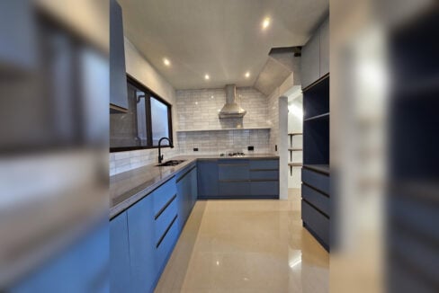 L-shaped kitchen with blue matte cabinets and a subway tile backsplash