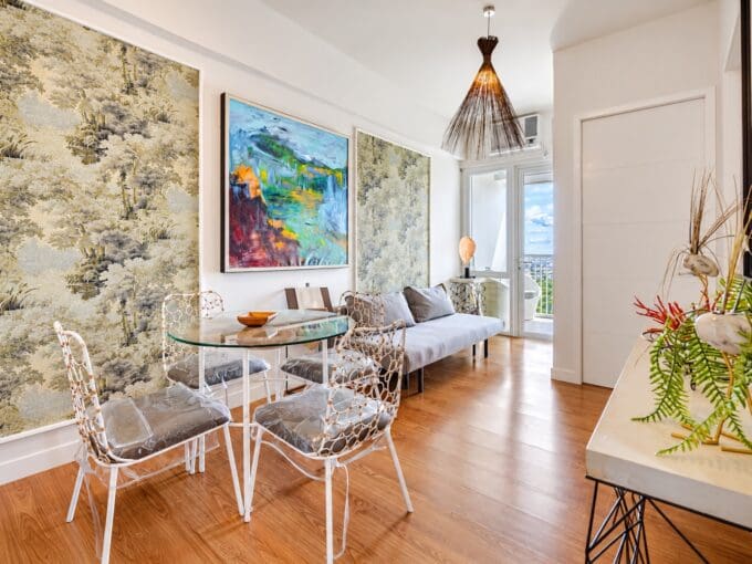 Living and dining area with round glass table, four chairs and sofa in a furnished 1BR condo for sale at Marco Polo Residences, Lahug