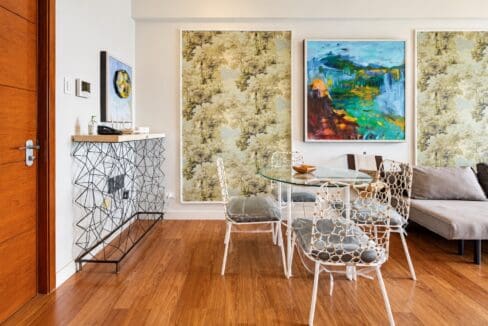 Dining table with four chairs beside a geometric wire-frame console table near the entry