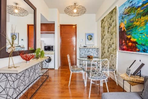 Open living and dining space with wall mirror, console table and kitchen niche in a Marco Polo Residences condo