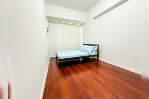 Second bedroom with a timber bed and roller blind