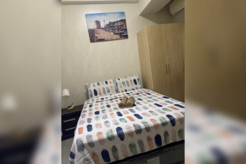 Bedroom with double bed, wooden wardrobe and bedside lamp