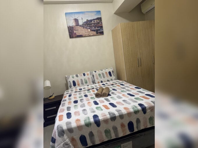 Bedroom with double bed, wooden wardrobe and bedside lamp