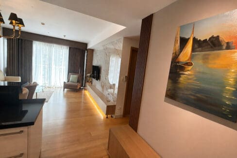 Entry of the Park Point unit, with a timber slat screen and framed artwork looking through to the living area