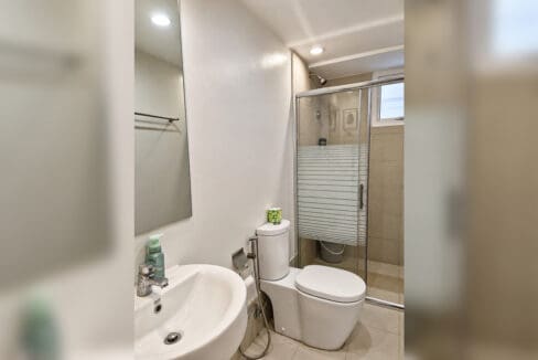 Bathroom with glass-enclosed shower and basin in the 2BR condo at Solinea Tower 3