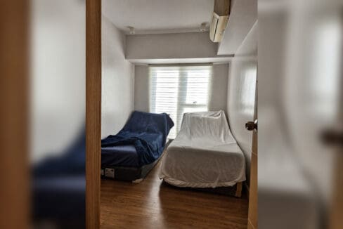 Bedroom with split-type air conditioning and wood-look flooring in the 2BR condo at Solinea Tower 3
