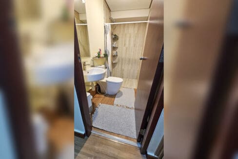 Bathroom with wall-hung basin, toilet and curtained shower