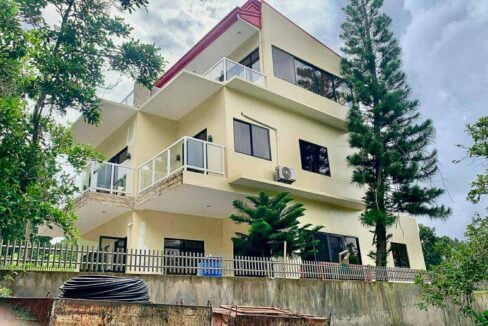 Three-level house with balconies and a fenced lot