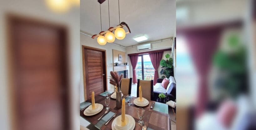 Dining area with pendant lights looking through to the living area and balcony in the 2BR at Soltana Nature Residences