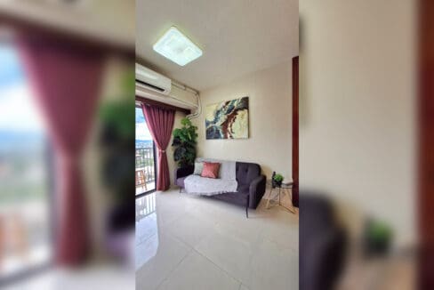Living area with sofa and balcony door in the 2BR at Soltana Nature Residences, Tower 1