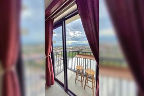 Balcony with timber ledge and stools overlooking Mactan in the 2BR at Soltana Nature Residences