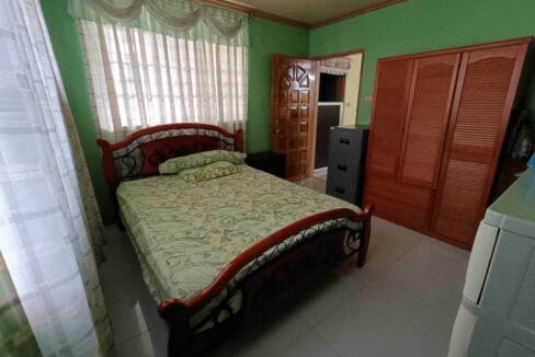 Bedroom with a queen bed and timber wardrobe in the four-bedroom house in Tubigon, Bohol