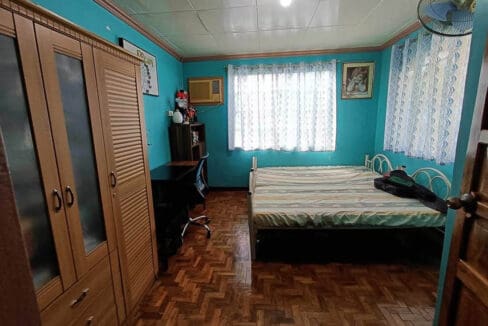 Bedroom with parquet flooring, built-in wardrobes and a study desk