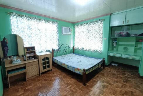 Bedroom with parquet flooring, a dressing table and built-in cabinets in the Tubigon house