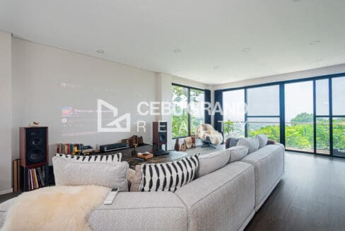 Living area of the Talisay house with floor-to-ceiling glazing framing the hillside view