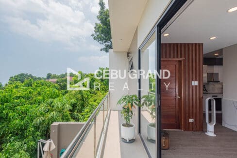 Narrow balcony with glass railing and potted plants off the living floor