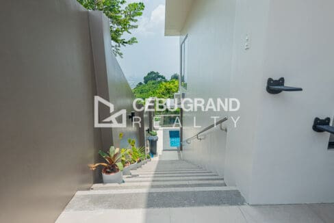 Side stairway running down past the house toward the pool level