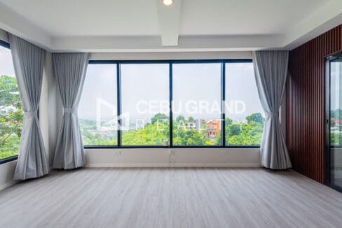 Light-filled upper room with floor-to-ceiling windows and full-height curtains
