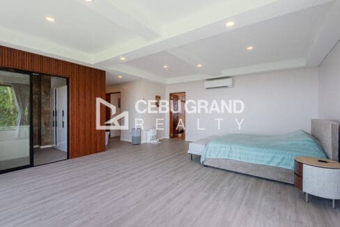 Master bedroom with a slatted timber feature wall, ensuite doorway and split-type air conditioning