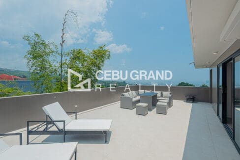 Roof deck of the Talisay house with sun loungers and an open outlook to the sea