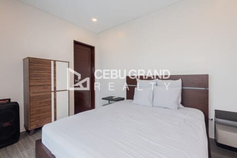Bedroom with tall timber wardrobes and a double bed