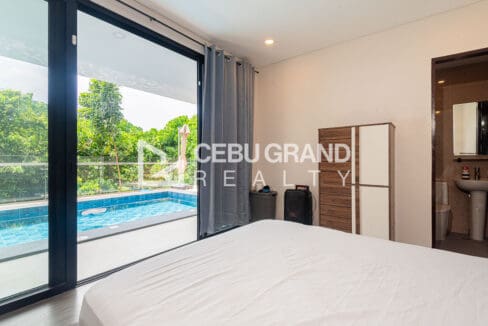 Poolside bedroom opening through sliding glass doors to the pool deck