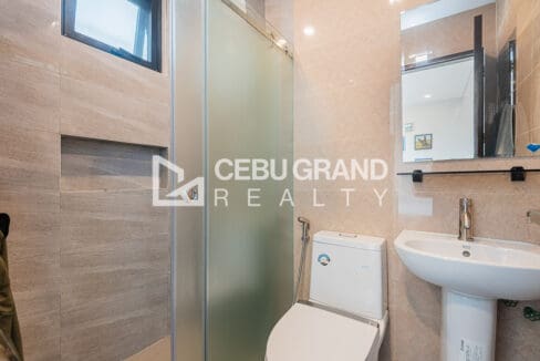 Bathroom with a glass shower enclosure, wall-hung basin and window
