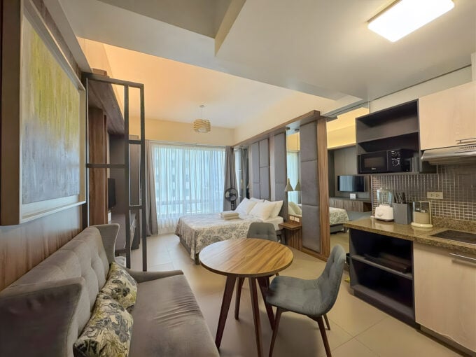 Furnished studio for rent at Asia Premier Residences with bed, sofa and round dining table