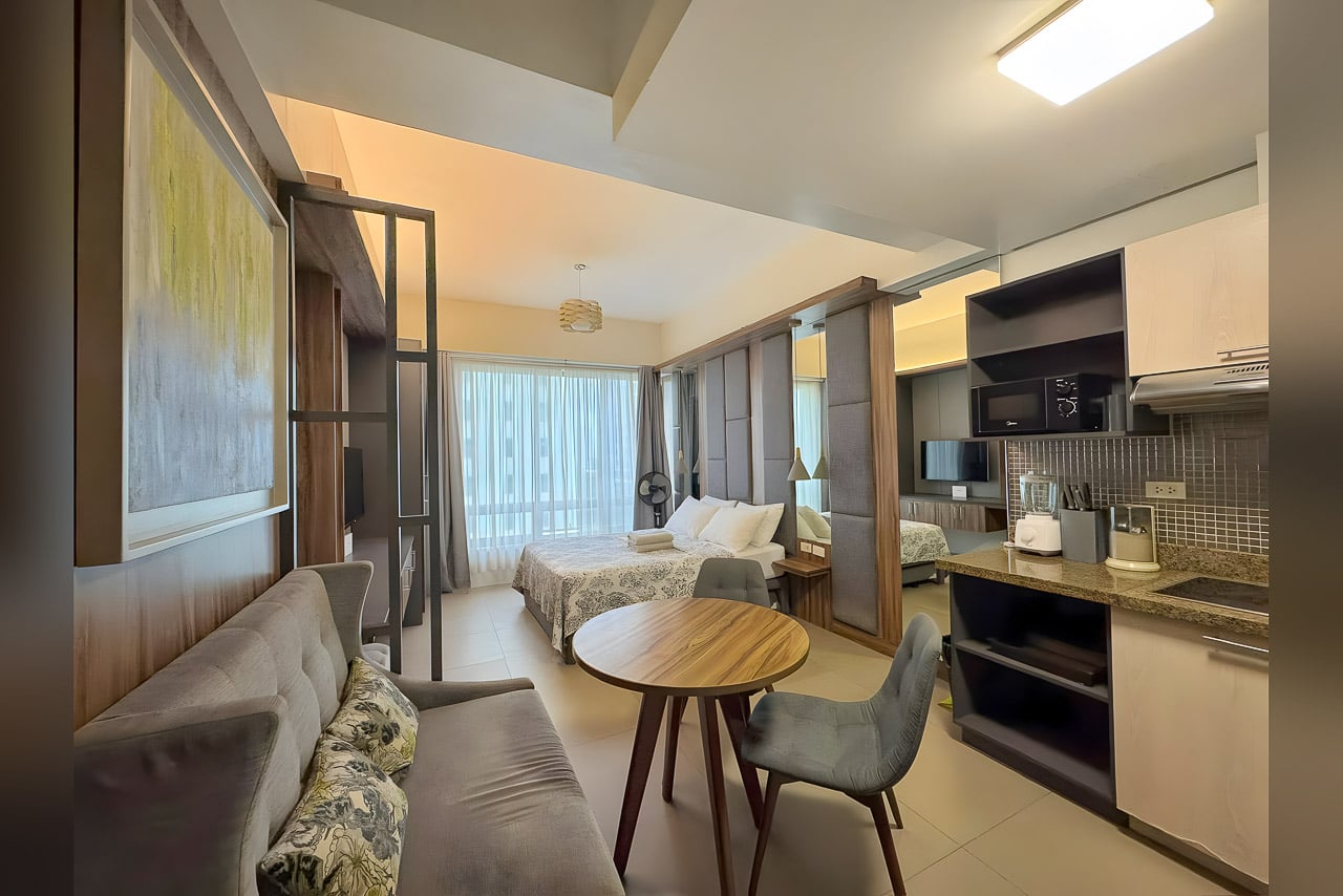 Furnished studio for rent at Asia Premier Residences with bed, sofa and round dining table