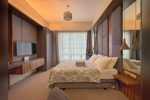 Bed below the full-width curtained window in the 6th-floor Asia Premier studio