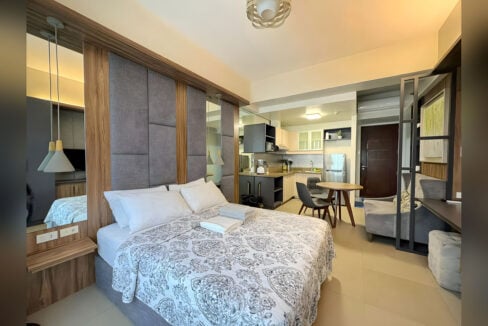 Bed facing the kitchen and split-type aircon in the furnished Asia Premier studio