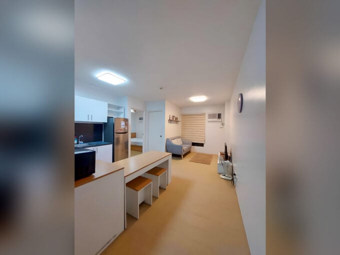 Furnished 1BR condo for rent at Avida Tower 2 with open-plan kitchen, dining counter and living area