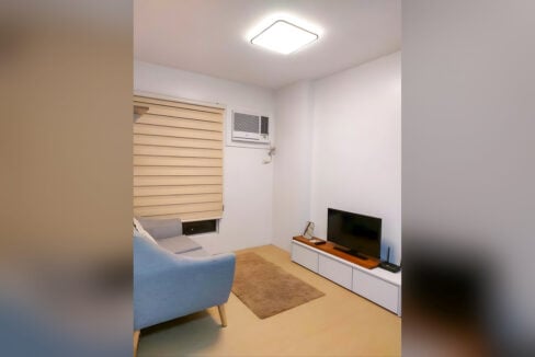 Combi blind, window-type aircon and TV on a wood-top console in the Avida Tower 2 condo