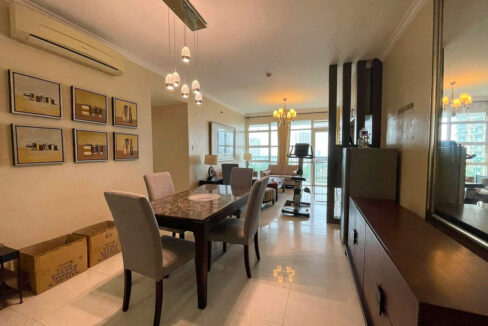 Dining area with a marble-top table and glass pendant lights, opening to the living room and balcony
