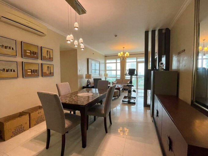 Dining area with a marble-top table and glass pendant lights, opening to the living room and balcony