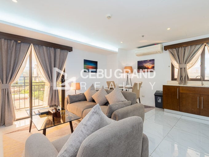 Living room of the 1 bedroom condo for rent in Kasambagan, with glass doors to the balcony