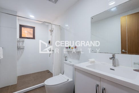 Bathroom with white subway tiles, rain shower and wide vanity mirror