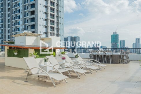 Roof deck sun loungers beside a high-top bar counter