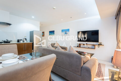 Living area with a floating TV shelf and framed beach prints