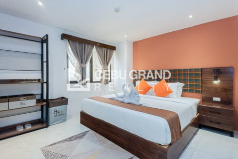 Bedroom at 88th Avenue with a king-size bed, plaid headboard and coral accent wall