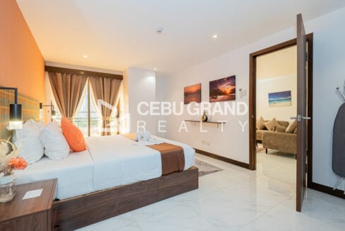 Bedroom with a balcony door, beach art and a door to the living room
