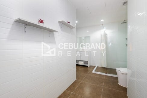 Large bathroom with white subway tiles, wall shelves and a glass-panel shower