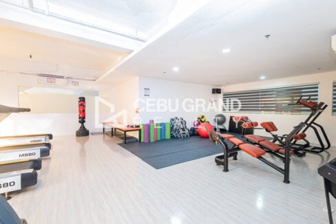 Gym stretching area with mats, foam rollers and a punching bag