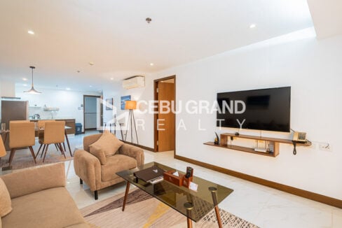 Wall-mounted TV on a floating wood shelf beside the living area