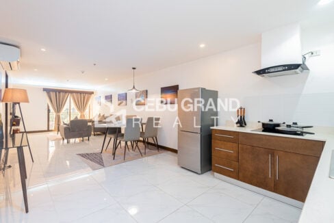 Open living, dining and kitchen area with marble-look floor tiles