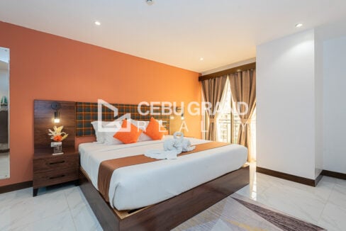 Bedroom at 88th Avenue with a king-size bed, plaid headboard and coral accent wall
